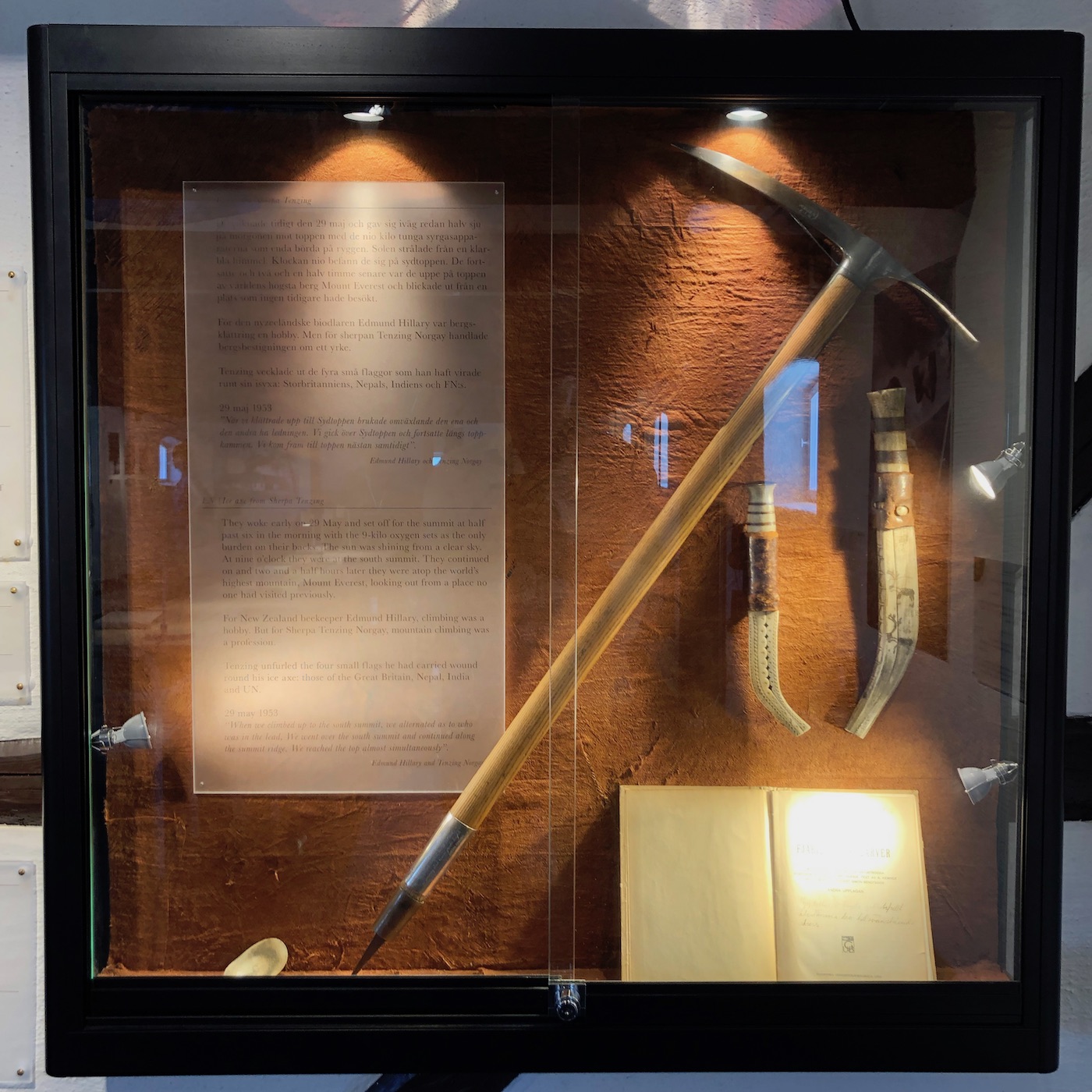 An ice axe and other items inside a glass cabinet
